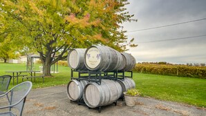 A wine barrel display outdoors with a picnic table and chairs nearby. - Cozy Ripley Apartment - 21 Mi to Downtown Erie! (Ripley)
