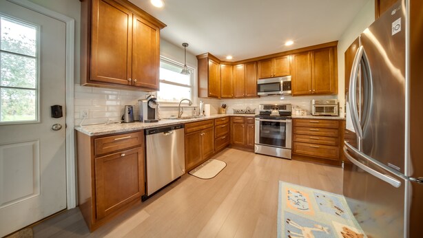 A modern kitchen with wooden cabinets, stainless steel appliances, and a large refrigerator. - Cozy Ripley Apartment - 21 Mi to Downtown Erie! (Ripley)