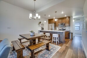 Une cuisine moderne avec des meubles en bois, un îlot central et des tabourets de bar.