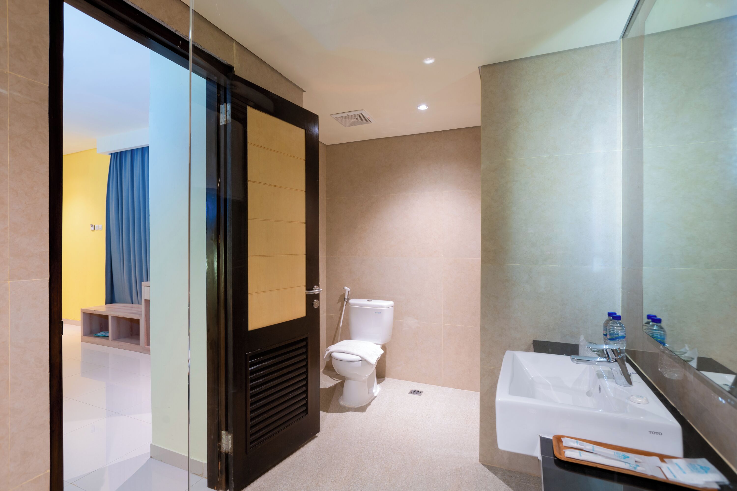 A modern bathroom with a toilet, sink, and mirror.
