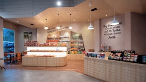 A bakery with a display counter, shelves with baked goods, and a wall with inspirational quotes. - ZASGO HOTEL (Labuan Bajo)