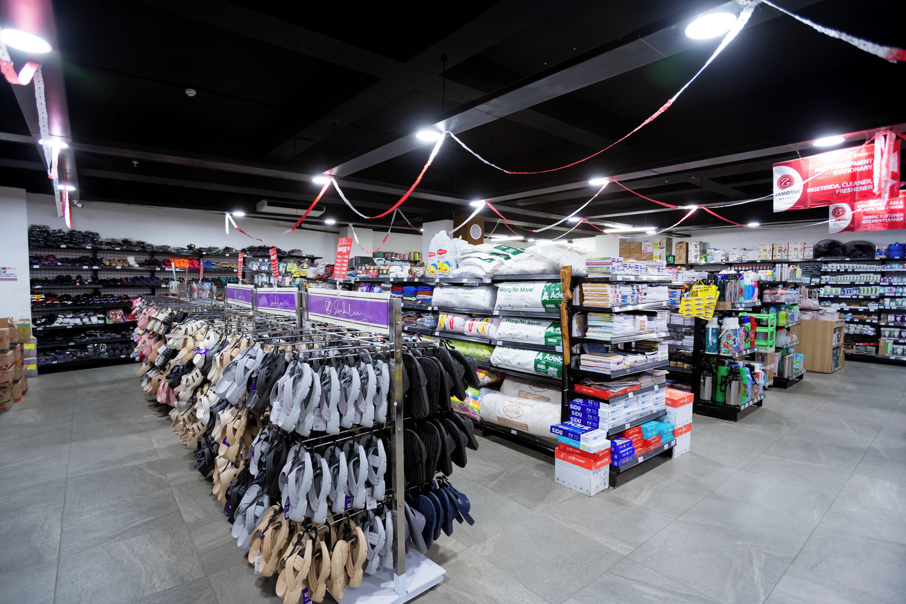 A retail store with shelves stocked with shoes and cleaning supplies.