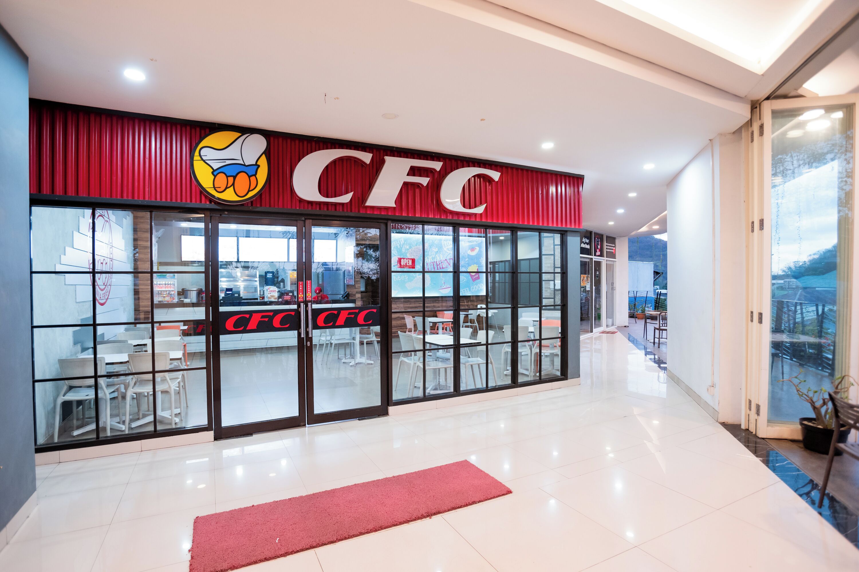 Een CFC restaurant met een rode luifel en een logo boven de ingang.