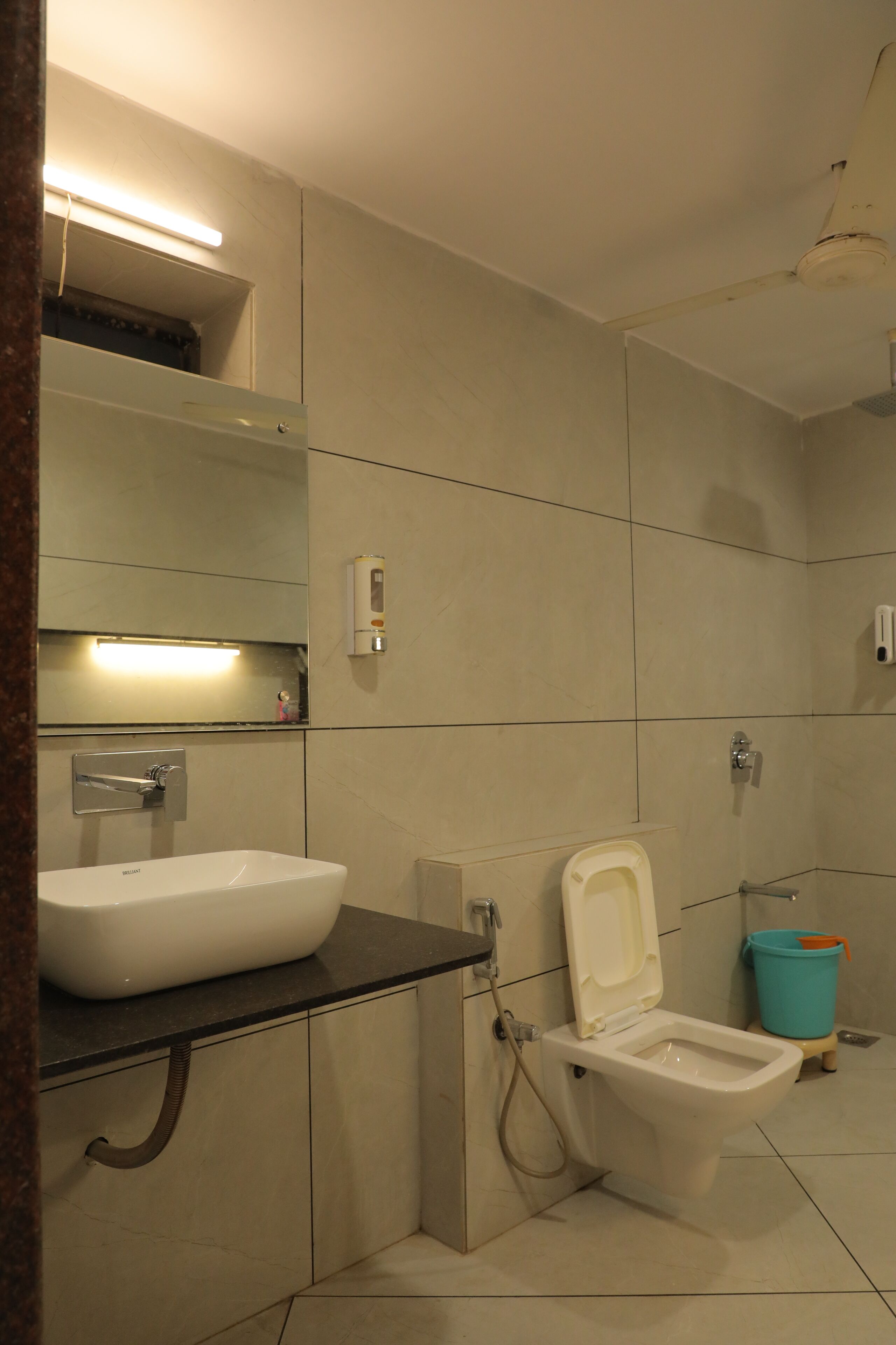 A modern bathroom with a white sink, a toilet, and a shower.