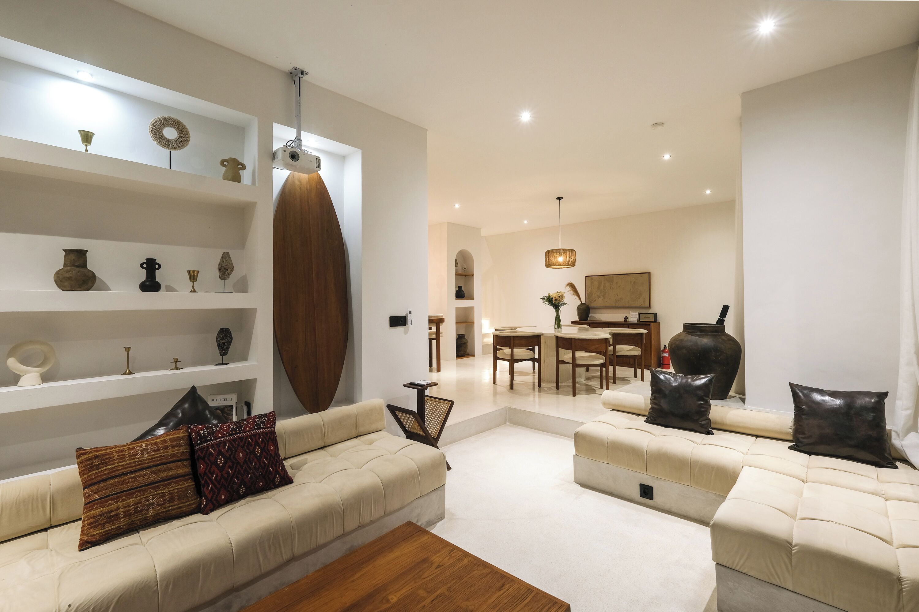 Un salon moderne avec un ensemble de canapés, une table basse en bois et un coin repas à l’arrière-plan.