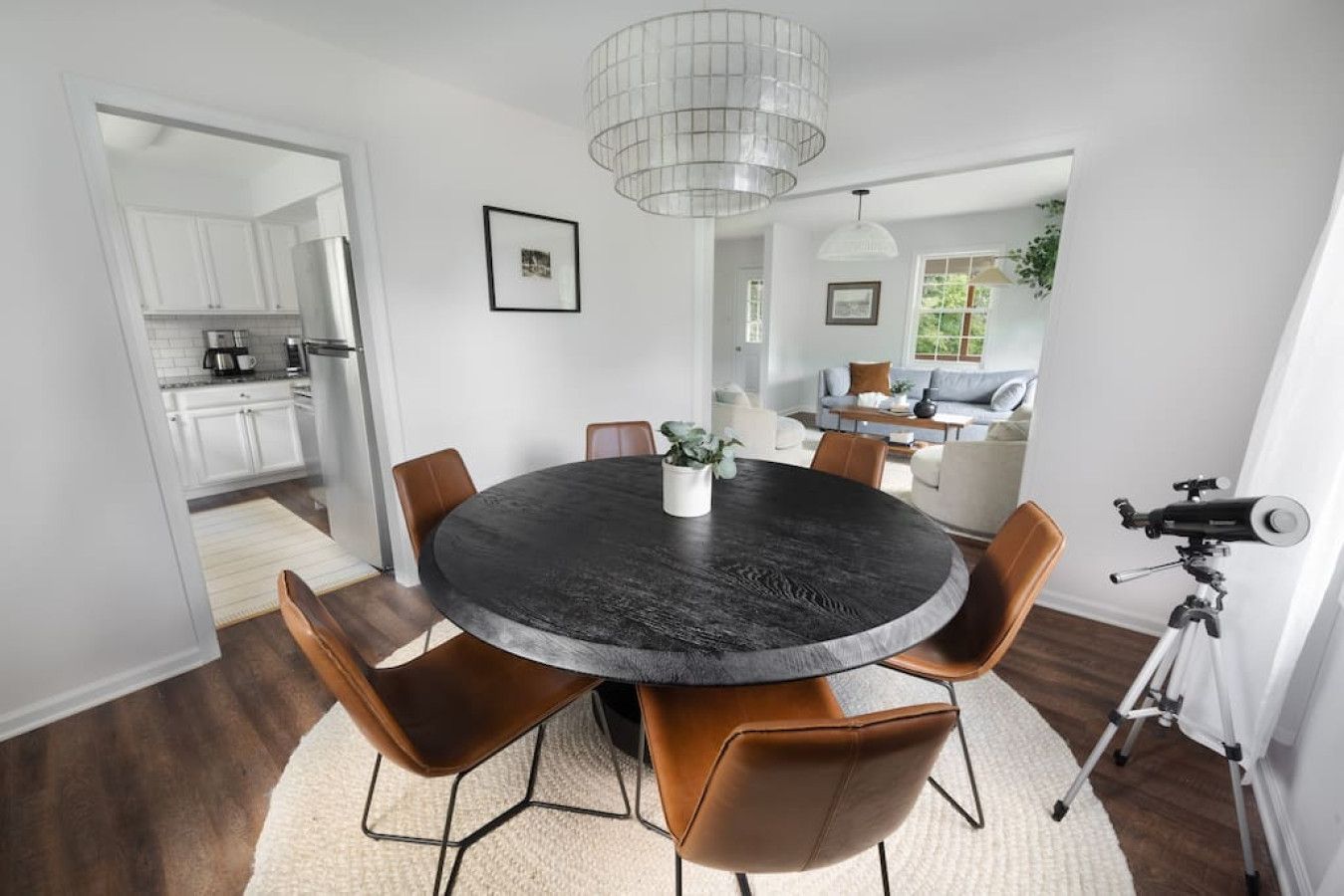A dining area with a round table, chairs, and a telescope.