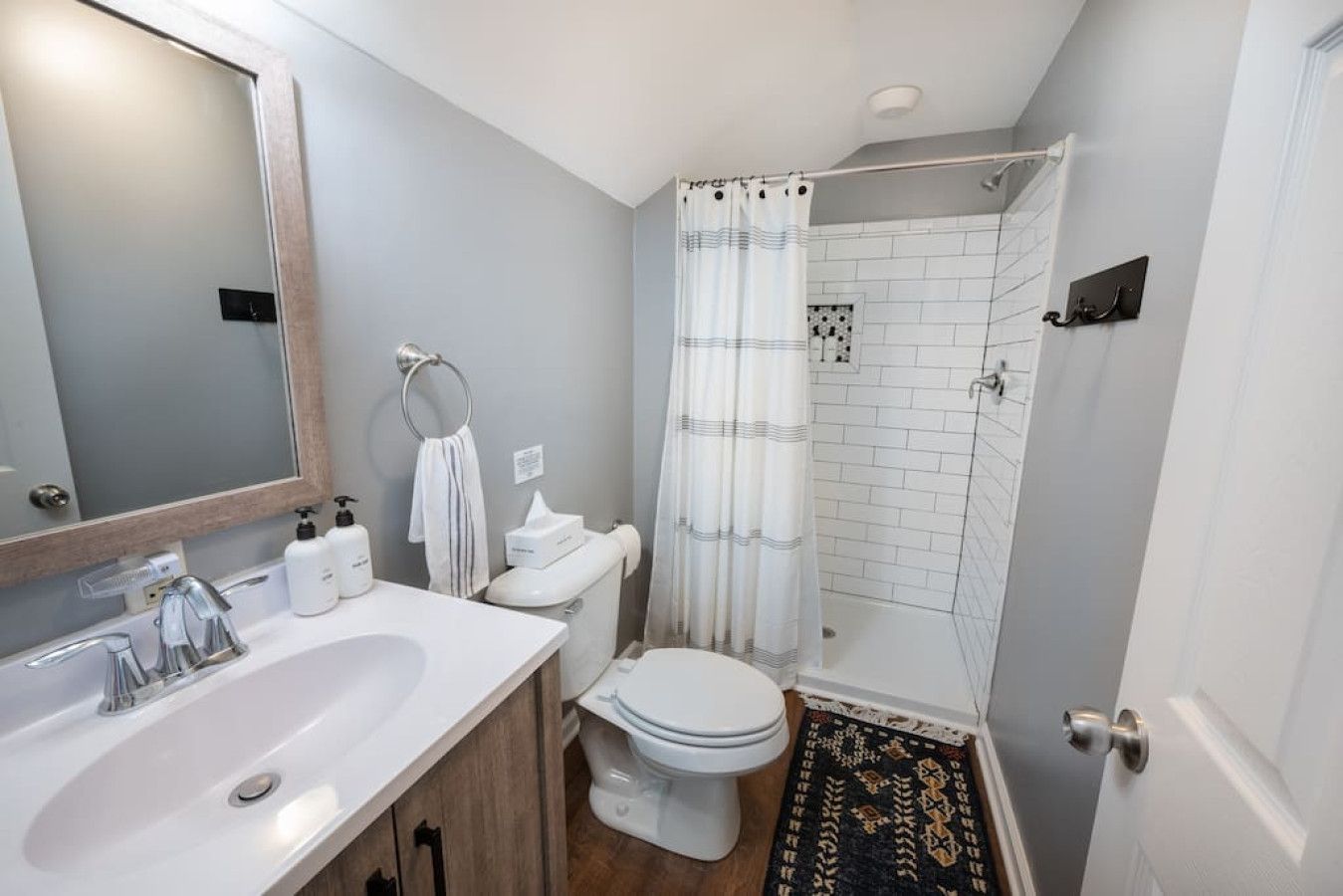 A bathroom with a sink, toilet, and shower area.
