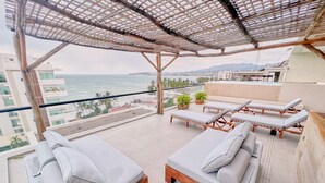 A rooftop terrace with lounge chairs, a pergola, and a view of the sea. - Arenka: 2BR w Private Pool & Sunset Rooftop (Bucerías)