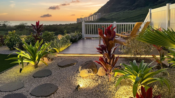 A deck with a view of the ocean and a mountainous landscape.