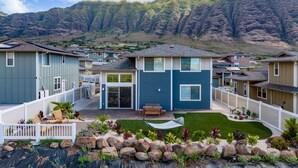 A residential area with houses, a well-maintained lawn, and a mountain in the background.
