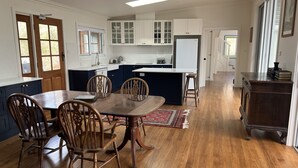 A modern kitchen with white cabinets, a wooden dining table, and chairs. - Beautiful Country Home.  5 min to Armidale, 10 min to University of New England. (Armidale)