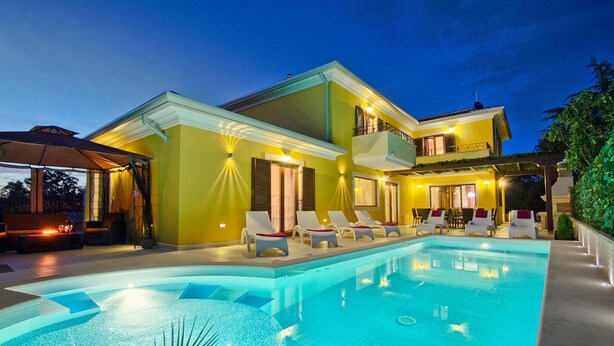 A modern house with a swimming pool, outdoor seating, and a well-lit patio area. - Gorgeous home in Pula (Pula)