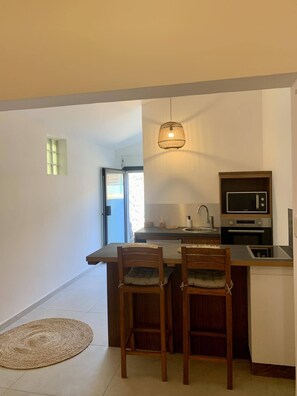 A compact kitchen with a dining area, a microwave, and a sink.