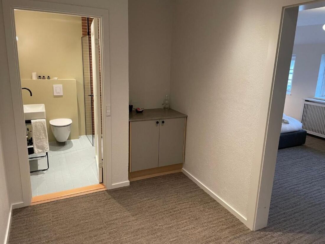 A small bathroom with a toilet, sink, and cabinet.