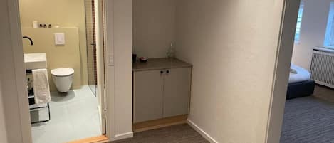 A small bathroom with a toilet, sink, and cabinet.