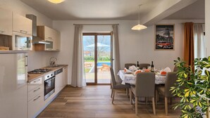 Una cucina moderna con zona pranzo, ampie finestre e vista sull'esterno.