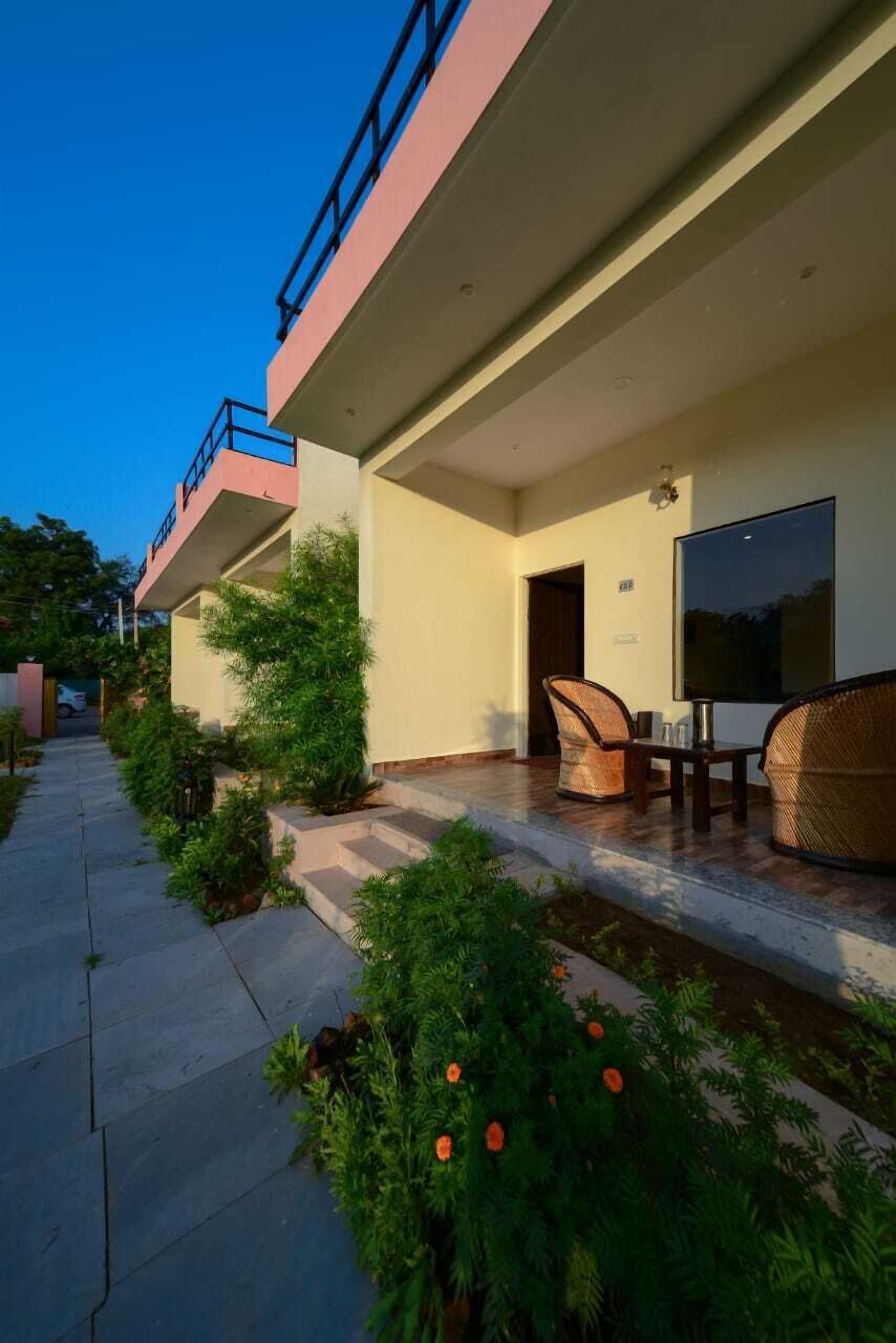 Un hotel con una zona de estar cubierta al aire libre, una escalera y vistas al cielo.