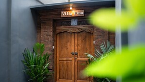 Une porte double en bois, au-dessus de laquelle on pouvait lire l’inscription « Villa Fina ».