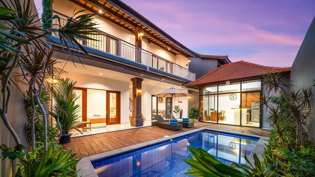Une maison moderne dotée d’une piscine, d’un balcon et d’un coin repas.