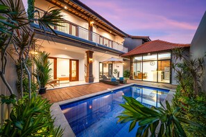 Una casa moderna con piscina, balcón y comedor.