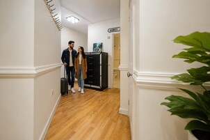 Un pasillo con piso de madera, un archivador negro y una puerta con la leyenda 'ABBEY'.
