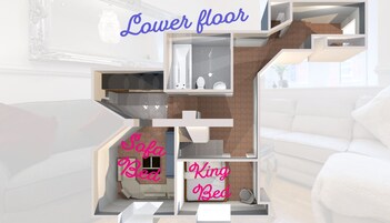 A modern interior with a lower floor, a sofa bed, and a king bed.