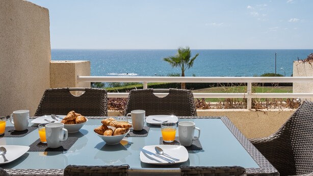 A breakfast table with croissants, orange juice, and coffee cups, overlooking the sea. - Chaparral Seafront by Alfresco Stays (Mijas Costa)