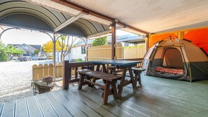 A covered outdoor area with a picnic table and benches, a tent, and a gravel driveway. - Gapyeong Lucerne Kids Spa Pension (Gapyeong)