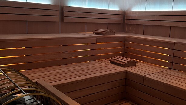 A sauna with wooden benches and a bench with a massage table.