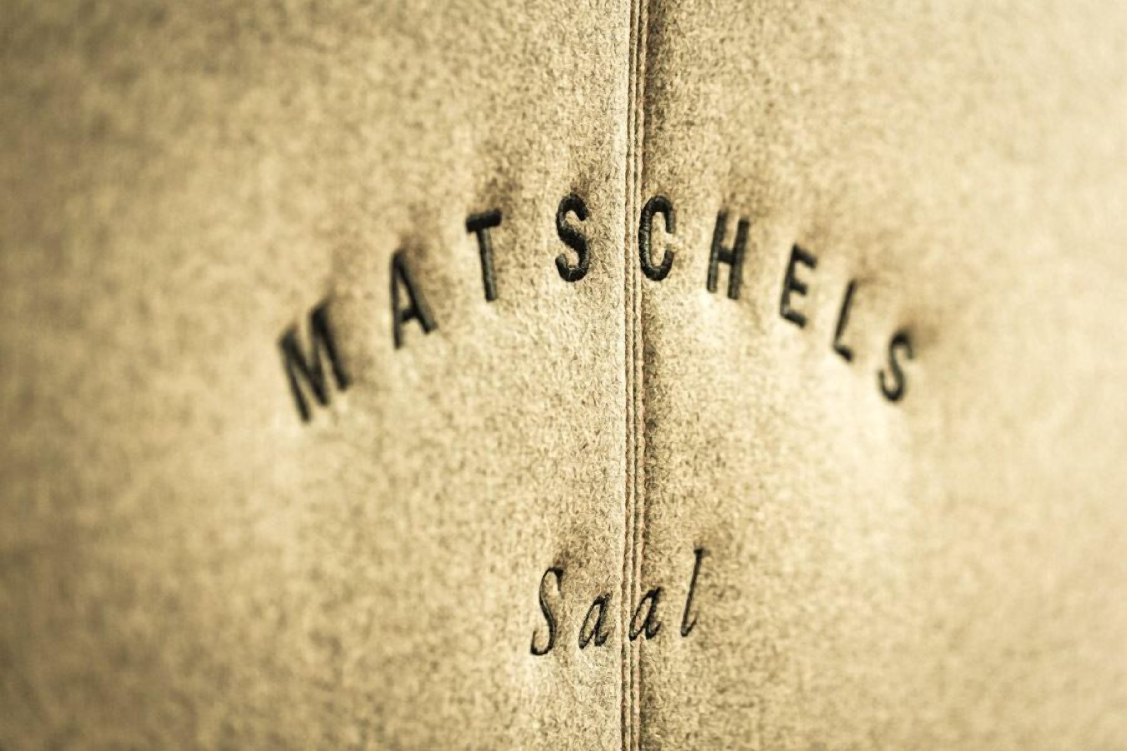 A close-up of a textured surface with the words "MATSCHELS" and "Salat" embossed on it.