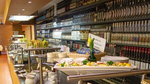 A buffet area with various food items and condiments.