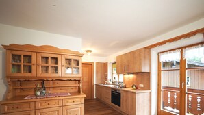 Una cucina con mobili in legno, un piano di lavoro e un forno a incasso.