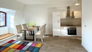 Eine moderne Wohnung mit Essbereich, Küche und Blick ins Freie.