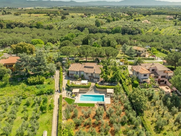 A residential area with multiple houses, a swimming pool, and lush greenery.