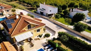 Un barrio residencial con casas modernas, una piscina y vistas a las colinas circundantes.