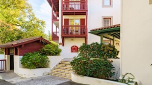 A two-story building with a balcony, a small porch, and a staircase leading to the entrance. - Les Terrasses d'Arcangues by Interhome (Arcangues)