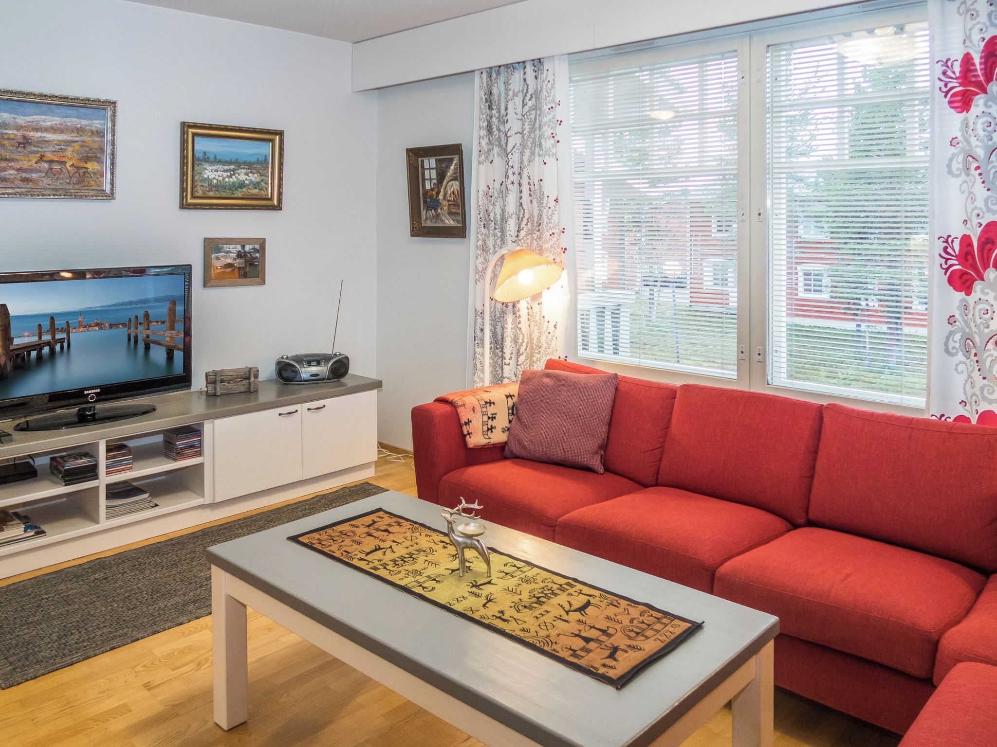 Un salon comprenant un téléviseur, un canapé, une table basse et des objets de décoration.