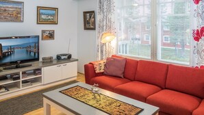 A modern living room with a television, sofa, and decorative items.