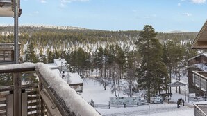 A snowy landscape with a view of a forest and a building with a sign that reads "Jordans".