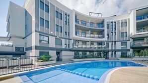 Un immeuble moderne doté d’une piscine et de nombreux balcons.