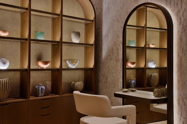 A room with a wooden desk, a chair, and shelves with decorative items. - The St. Regis Red Sea Resort (Umluj)