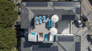 Vista aérea de una azotea con paneles solares, mobiliario exterior y una zona de piscina.
