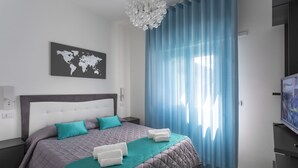 Un dormitorio moderno con una cama grande, un mapa del mundo en la pared y un televisor sobre un mueble.