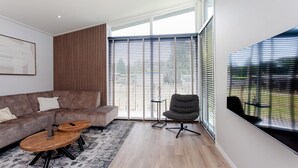 A modern living room with a grey sofa, a wooden coffee table, and a grey armchair. - 2 bedroom nice home in Voorthuizen (Voorthuizen)