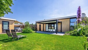 A modern house with a covered patio, a lawn, and a barbecue area. - 2 bedroom nice home in Voorthuizen (Voorthuizen)