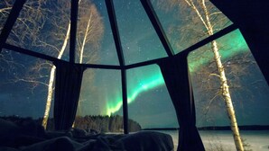 A room with a large window, a bed, and a view of the Northern Lights. - Aito  Igloo & Spa Resort (Rovaniemi)