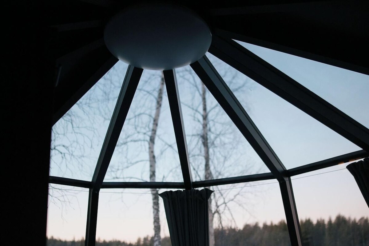 A room with a bed, a window, and a view of a snowy landscape.