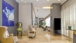 A modern hotel lobby with a long corridor, seating areas, and a large window. - Damac Majestine (Dubai)