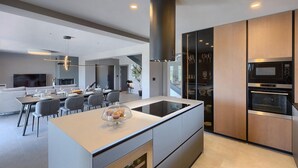 Una cocina moderna con una isla central, horno empotrado y microondas.