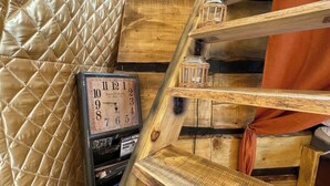 A wooden interior with a quilted wall, a clock, and shelves with items. - Lake View Dome Sleeps 6 -hot tub -fireplace (Horni Podluzi)